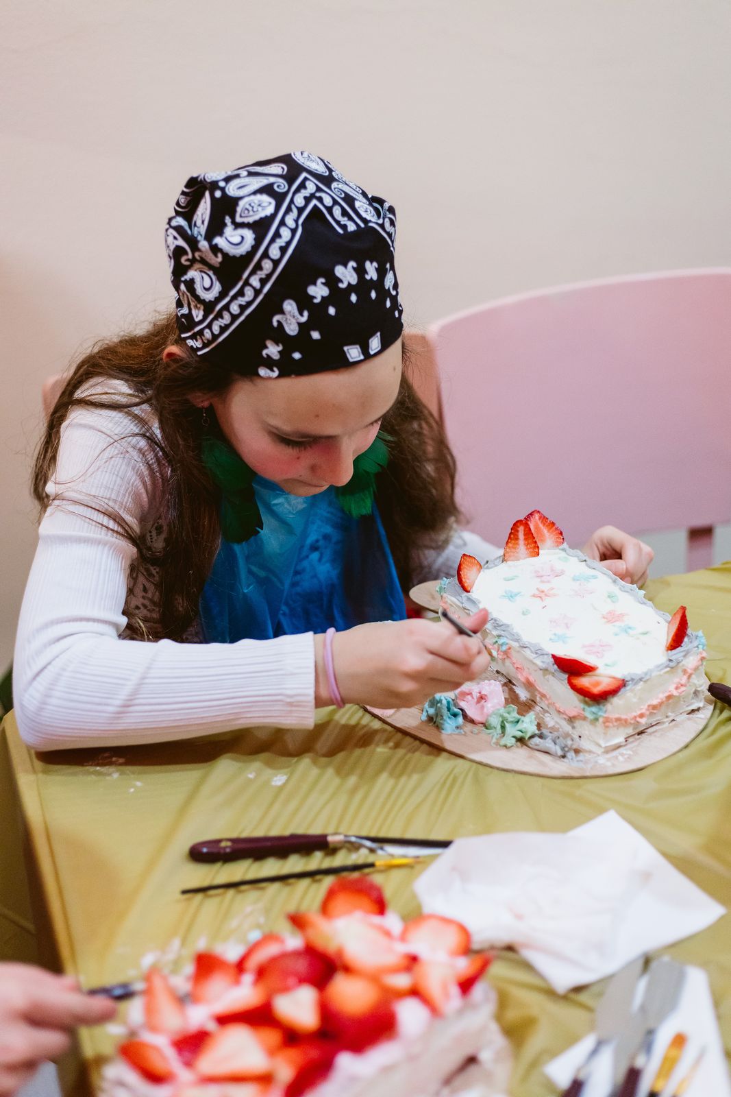 Copil pictând un tort cu pensula, la atelierul de pictură pe tort de la Artizan
